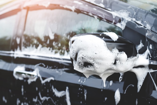 Outdoor car wash with active foam soap. commercial cleaning washing service concept.