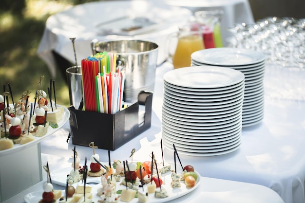 Foto banchetto catering all'aperto in estate tavolo con snack, tartine e frutta in un banchetto estivo