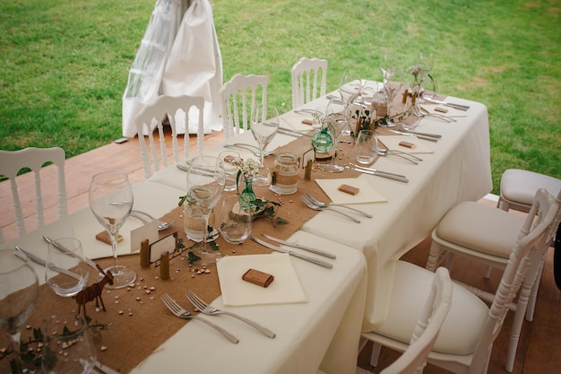 Outdoor catering dinner at the wedding with homemade garnishes decoration Rustic and boho style decor natural materials figures of deer green and brown