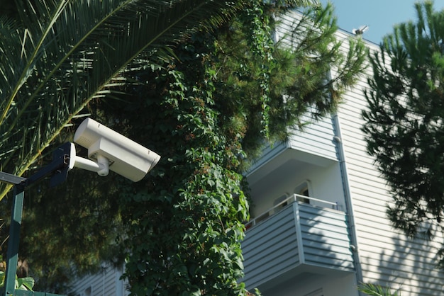 バルコニー付きの家の背景に晴れた日の屋外CCTVカメラ