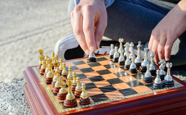 Outdoor chess game Wooden chessboard with silver and gold pieces Closeup