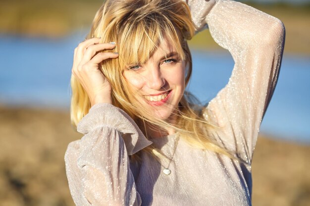 Outdoor close up portrait beautiful blonde girl with youth and skin care attractive looking at camera Light key