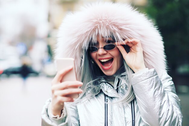 Outdoor close up portrait of woman using mobile phone