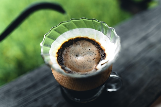 Outdoor drip coffee maker on wooden table rice field background