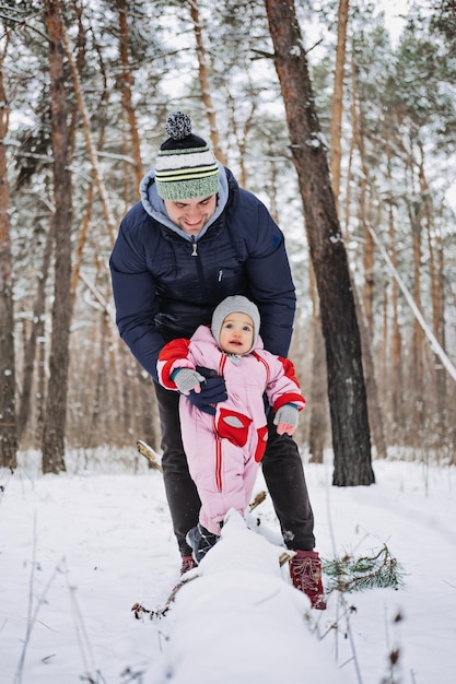 Attività familiari all'aperto per buone vacanze invernali padre felice che gioca con il piccolo bambino piccolo