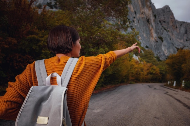 写真 山の中の秋の森に囲まれた若い美しい女性のアウトドアファッション写真