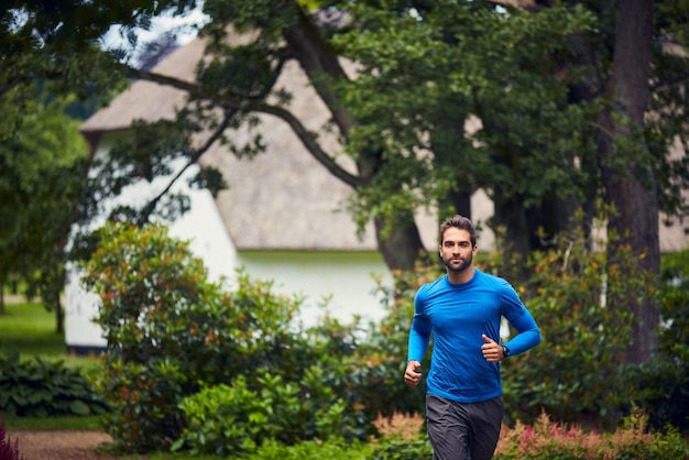 outdoor fitness and man in park for running challenge wellness and healthy morning exercise training cardio and runner on path in nature with commitment progress and athlete in muscle workout