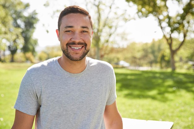 Photo outdoor head and shoulders portrait of smiling man in park