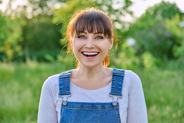 Foto ritratto all'aperto di una donna matura e sorridente in campagna