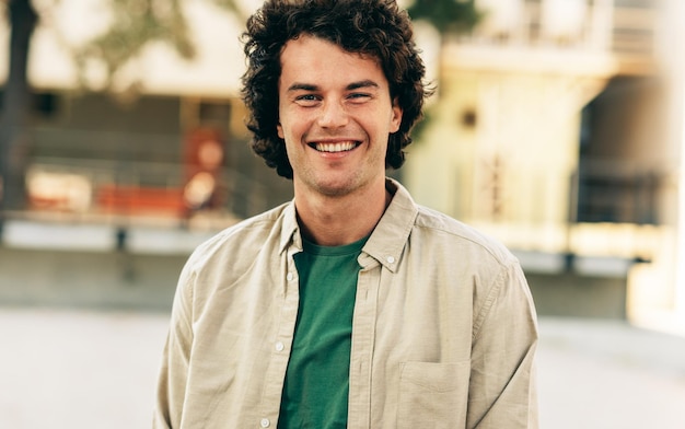 outdoor horizontal portrait of happy handsome young man smiling and posing for advertisement looking at the camera standing at city street happy smart student male posing outside people emotion