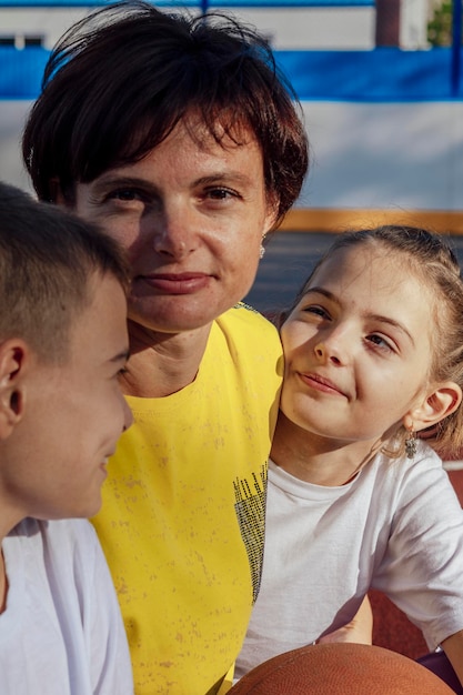 Foto abbracci all'aperto madre e figli adolescenti coccolati dolcemente al sole