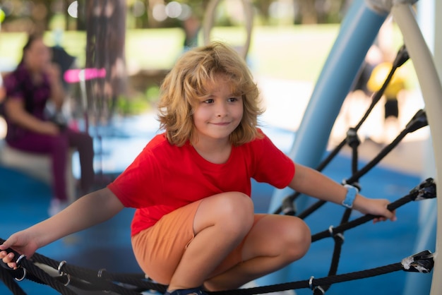 Outdoor kids portret op speelplaats kleine jongen spelen op de speelplaats de emotie van geluk fu