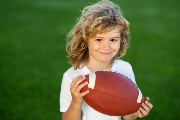 Outdoor kinderen sportactiviteiten jongen jongen plezier hebben en Amerikaans voetbal spelen op groen gras park