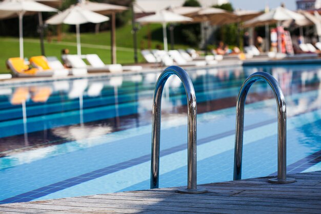 Grande piscina blu all'aperto in loco con scale per scendere in acqua