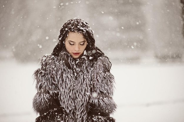 Outdoor lifestyle fashion photo of young natural beautiful lady in winter landscape