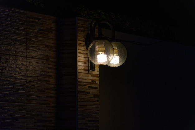 Outdoor lighting fixtures turned on in the dark exterior of a home