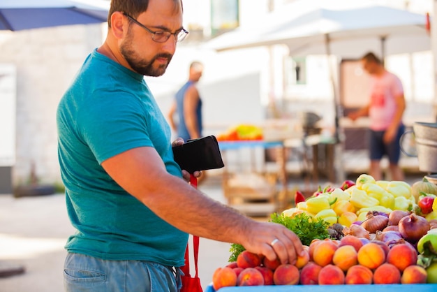 Outdoor market vegetable stand and customer, morning bazar