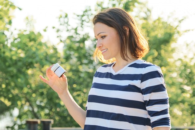 Outdoor middelbare leeftijd vrouw met medicijnen, vitamines, supplementen