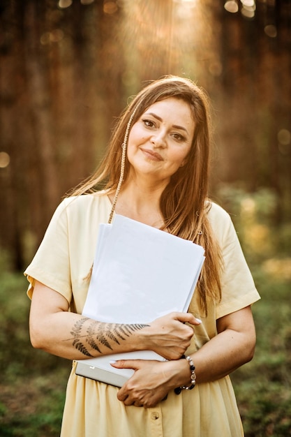Outdoor mockup with woman holding empty paper document sheet with copy space