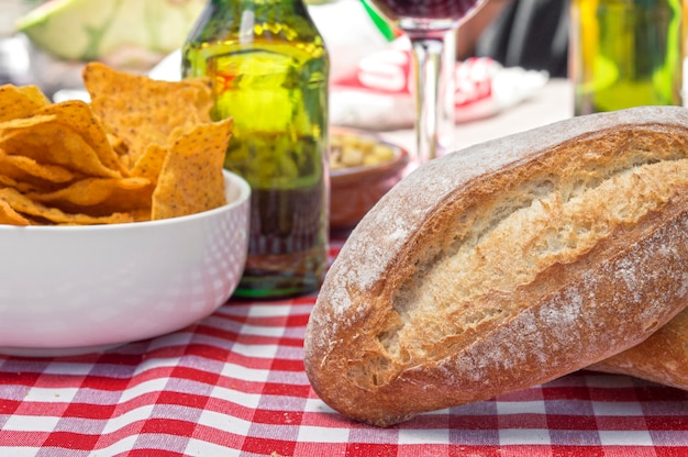 Outdoor picnic, bread, beers, wine and snacks in spring.