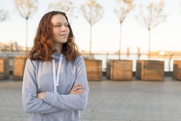 Ritratto all'aperto di bella ragazza sorridente dell'adolescente 14, 15 anni