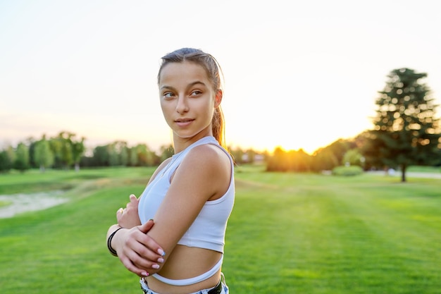 Outdoor portrait of beautiful teenage smiling girl