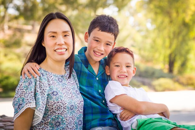 Outdoor portrait of biracial Chinese and Caucasian brothers and their mother