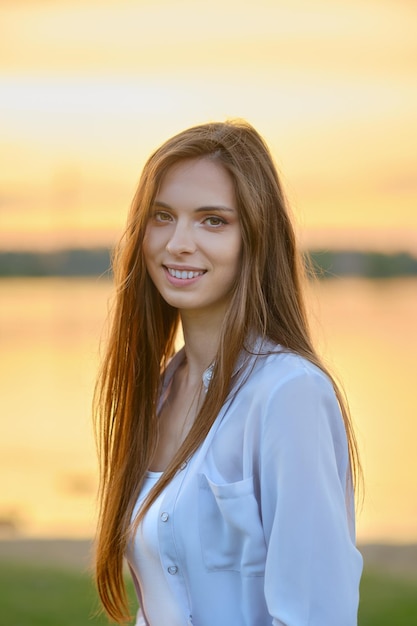 Outdoor portrait of cute woman at sunset