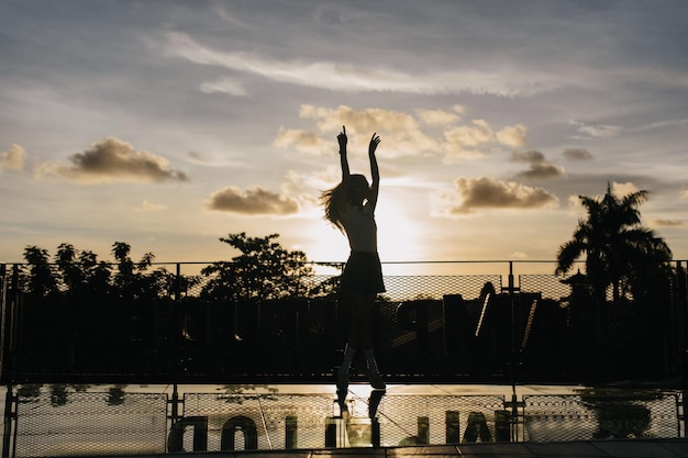 Outdoor portrait of dancing young woman having fun in evening Photo of graceful female model spending time on the street during sunset