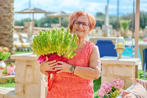 Outdoor portrait of an elderly beautiful woman of s age looking at camera