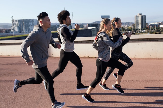 Outdoor portrait of group of friends running in the city.