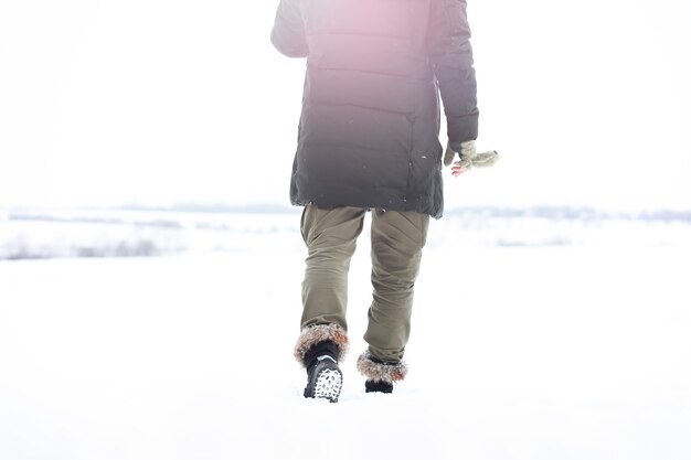 コートとスカーフのハンサムな男の屋外の肖像画。冬の森のひげを生やした男。