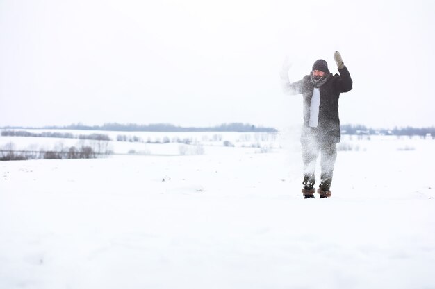 Outdoor portrait of handsome man in coat and scurf. Bearded man in the winter woods.