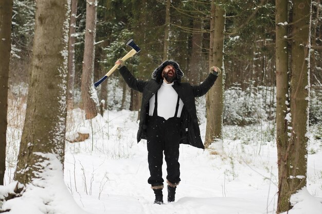 Outdoor portrait of handsome man in coat and scurf. Bearded man in the winter woods.