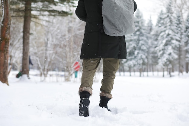 Outdoor portrait of handsome man in coat and scurf. Bearded man in the winter woods.