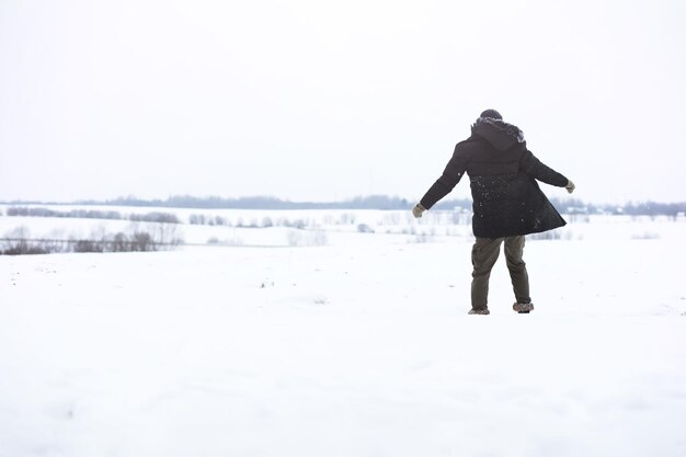 Outdoor portrait of handsome man in coat and scurf bearded man\
in the winter woods