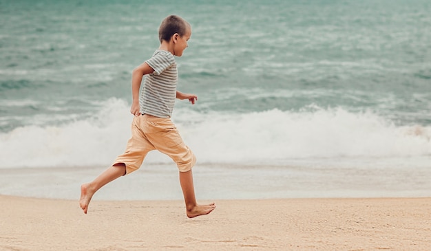 写真 走っている小さなかわいい男の子の屋外の肖像画