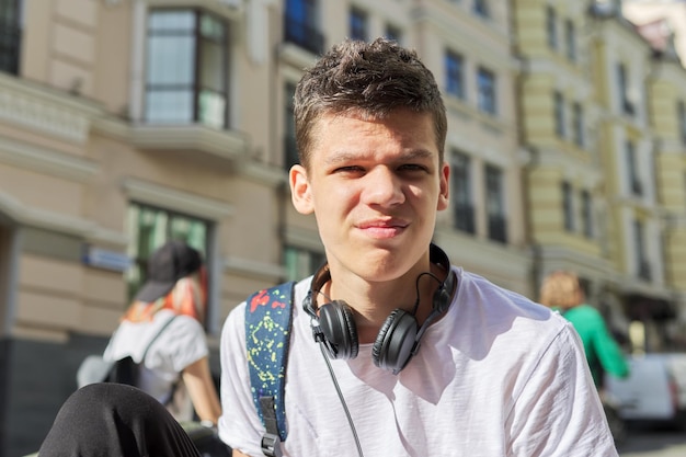 Outdoor portrait of a serious teenage guy looking at the camera