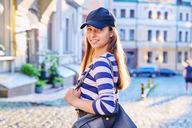 Photo outdoor portrait of teenage girl in black cap city street background