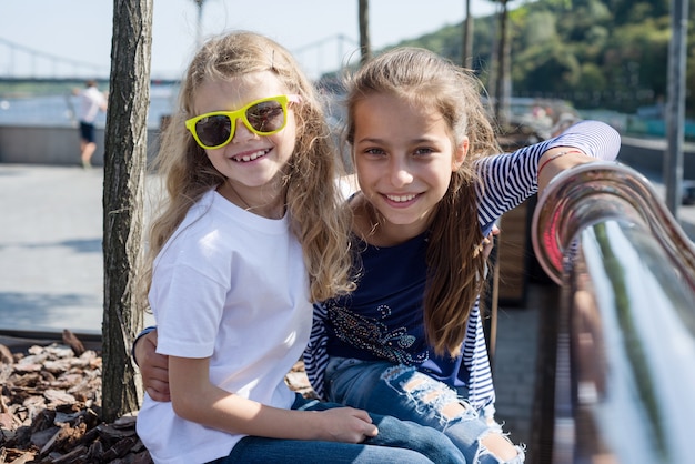 Outdoor portrait of two happy smiling little girls