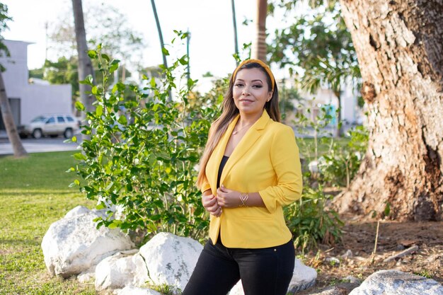 Outdoor portrait of woman in yellow jacket Portrait of young Mexican woman in a garden at sunset