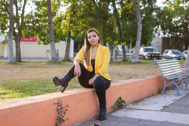 Outdoor portrait of woman in yellow jacket Portrait of young Mexican woman in a garden at sunset