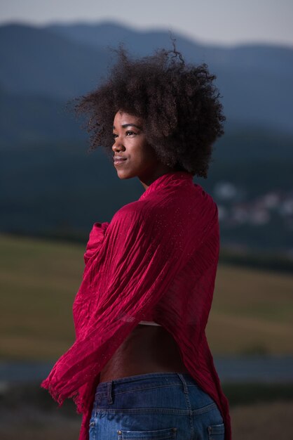 Outdoor portrait of young beautiful black woman with red scarf around shoulder