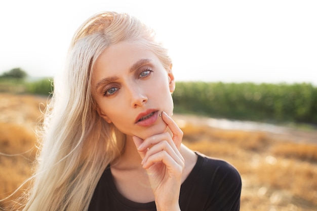 Outdoor portrait of young beautiful blonde girl in the wheat field.