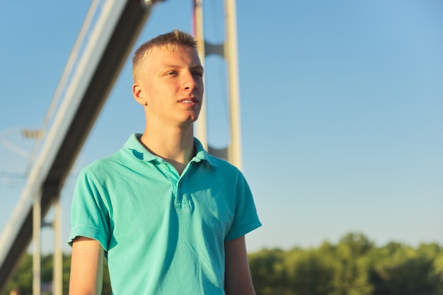 Outdoor portrait of young blond male, serious confident teenager