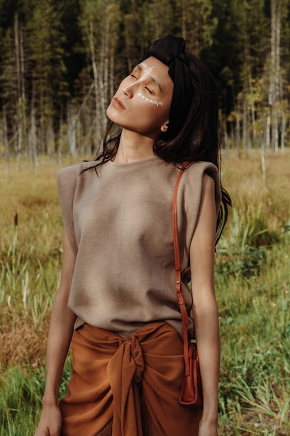 Outdoor portret van een prachtige Aziatische vrouw met authentieke make-up en stijlvolle jurk onder de zon