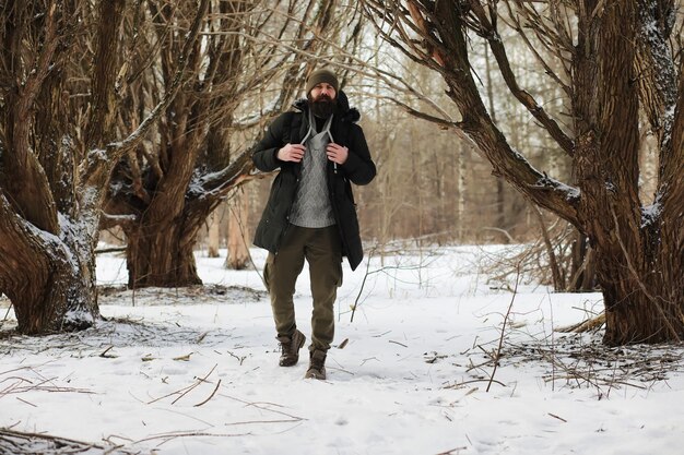 Outdoor Portret van knappe man in jas en scurf. Bebaarde man in het bos van de winter.