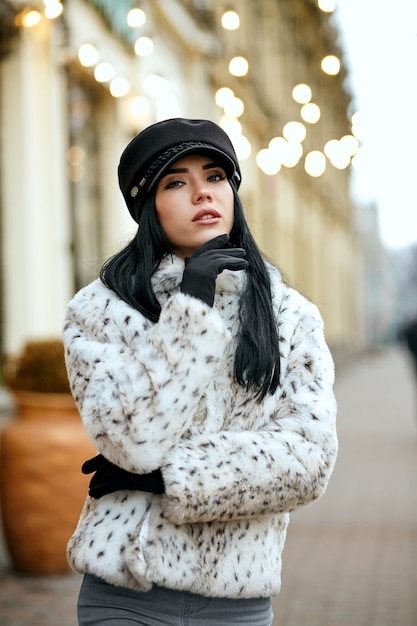 Outdoor portret van modieus gekleed jong model poseren op straat