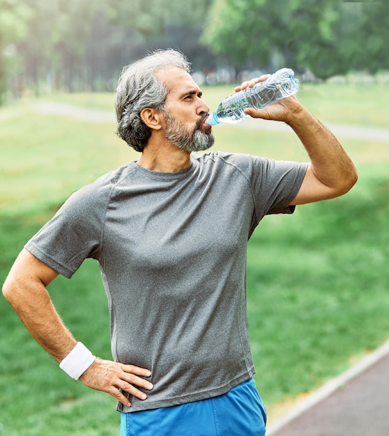Outdoor senior fitness man lifestyle active sport exercise healthy fit retirement jogging running bottle water drink drinking thirsty dehydration hudration