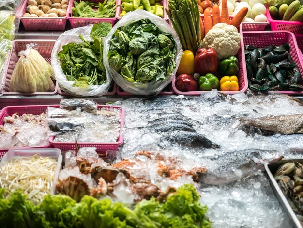 Foto negozio all'aperto che vende frutti di mare, verdure